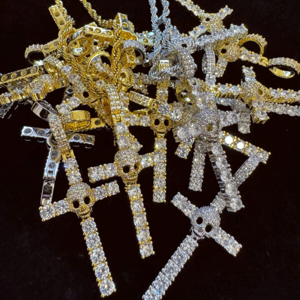 ICETOPLUXE assorted iced out skull cross pendants stacked, perfect for custom hip hop jewelry