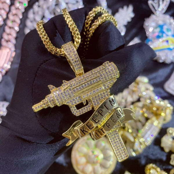 ICETOPLUXE close-up of the iced out gun pendant, showcasing dazzling diamond-like CZ shine for hip hop fans