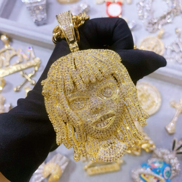 ICETOPLUXE close-up of gold iced out dreadlocks pendant, a bold statement in hip hop jewelry