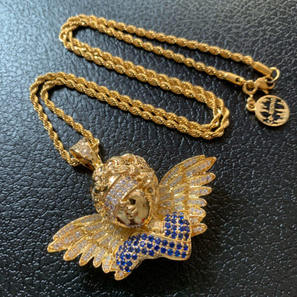 Close-up front view of ICETOPLUXE gold plated blindfold angel pendant, iced out with blue CZ diamonds, hip hop jewelry for men